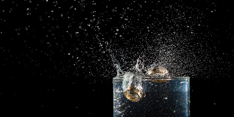 Wedding rings falling into a glass